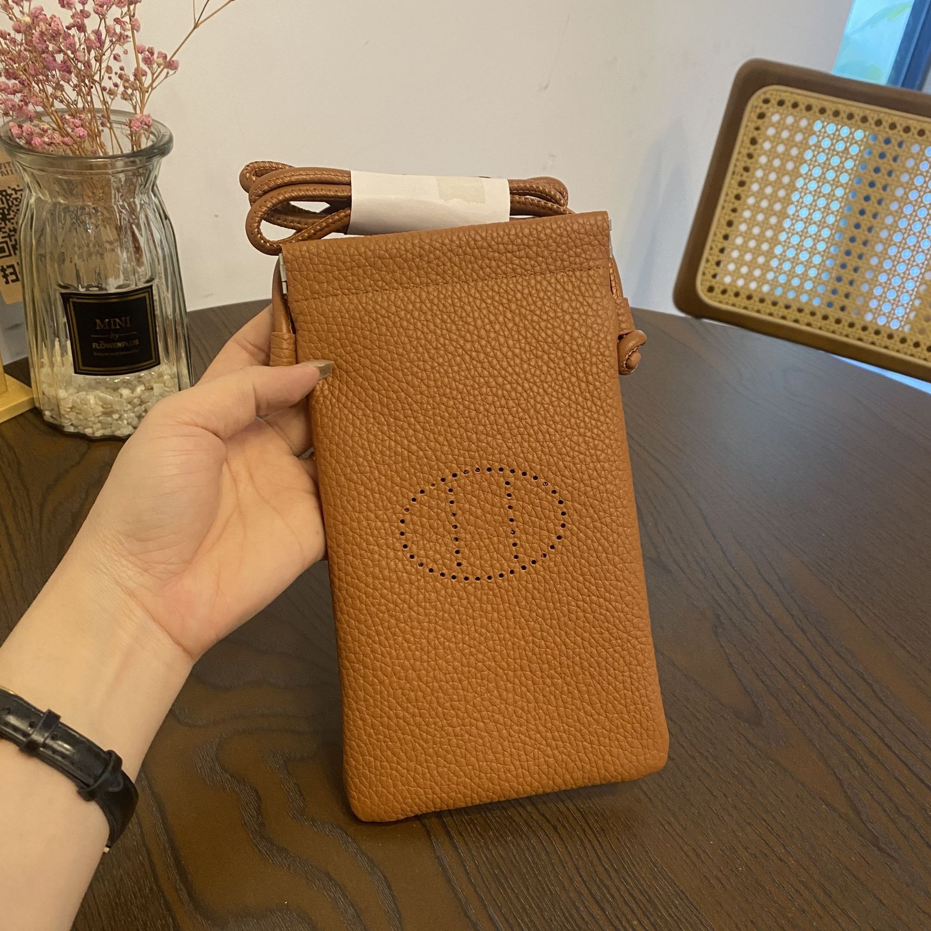 Picture of New first layer cowhide vertical mobile phone bag fashion simple shoulder messenger bag hollow soft leather drawstring small square bag