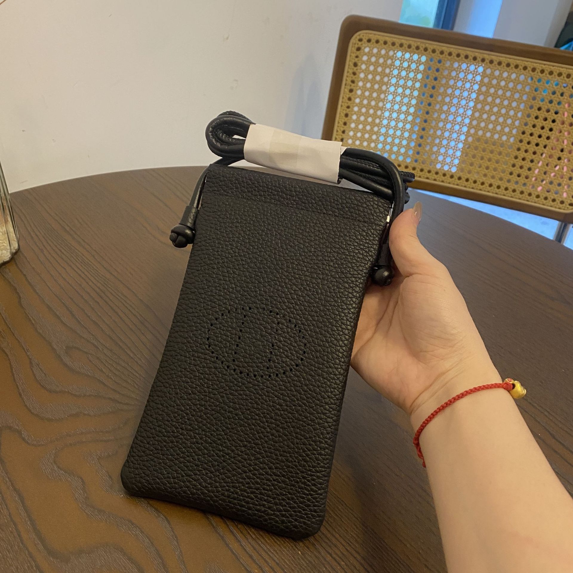 Picture of New first layer cowhide vertical mobile phone bag fashion simple shoulder messenger bag hollow soft leather drawstring small square bag