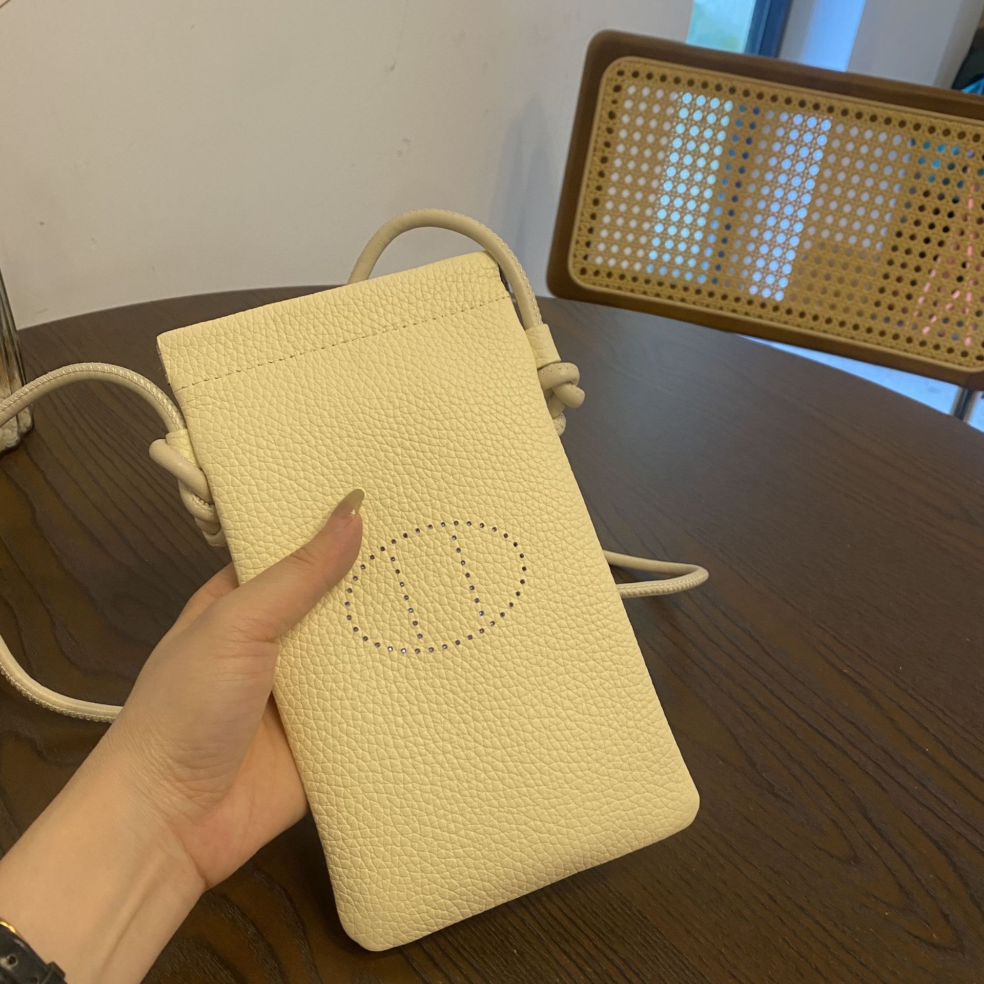 Picture of New first layer cowhide vertical mobile phone bag fashion simple shoulder messenger bag hollow soft leather drawstring small square bag