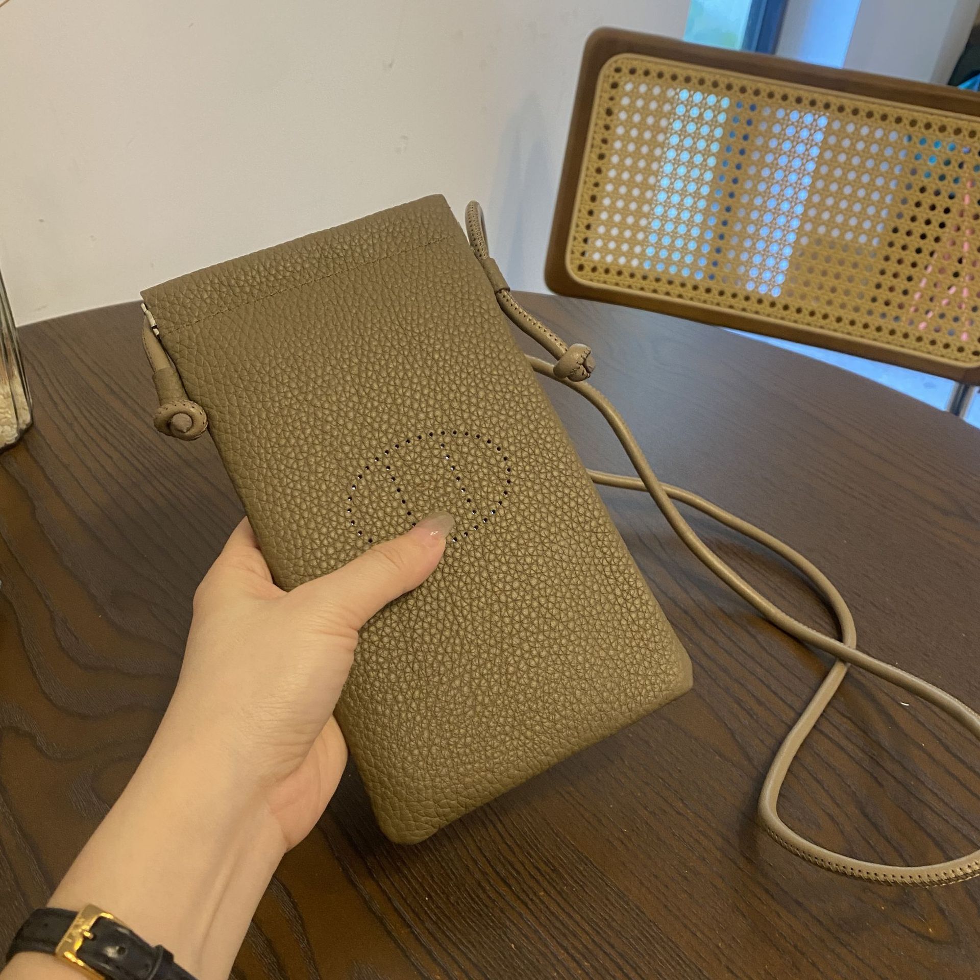 Picture of New first layer cowhide vertical mobile phone bag fashion simple shoulder messenger bag hollow soft leather drawstring small square bag