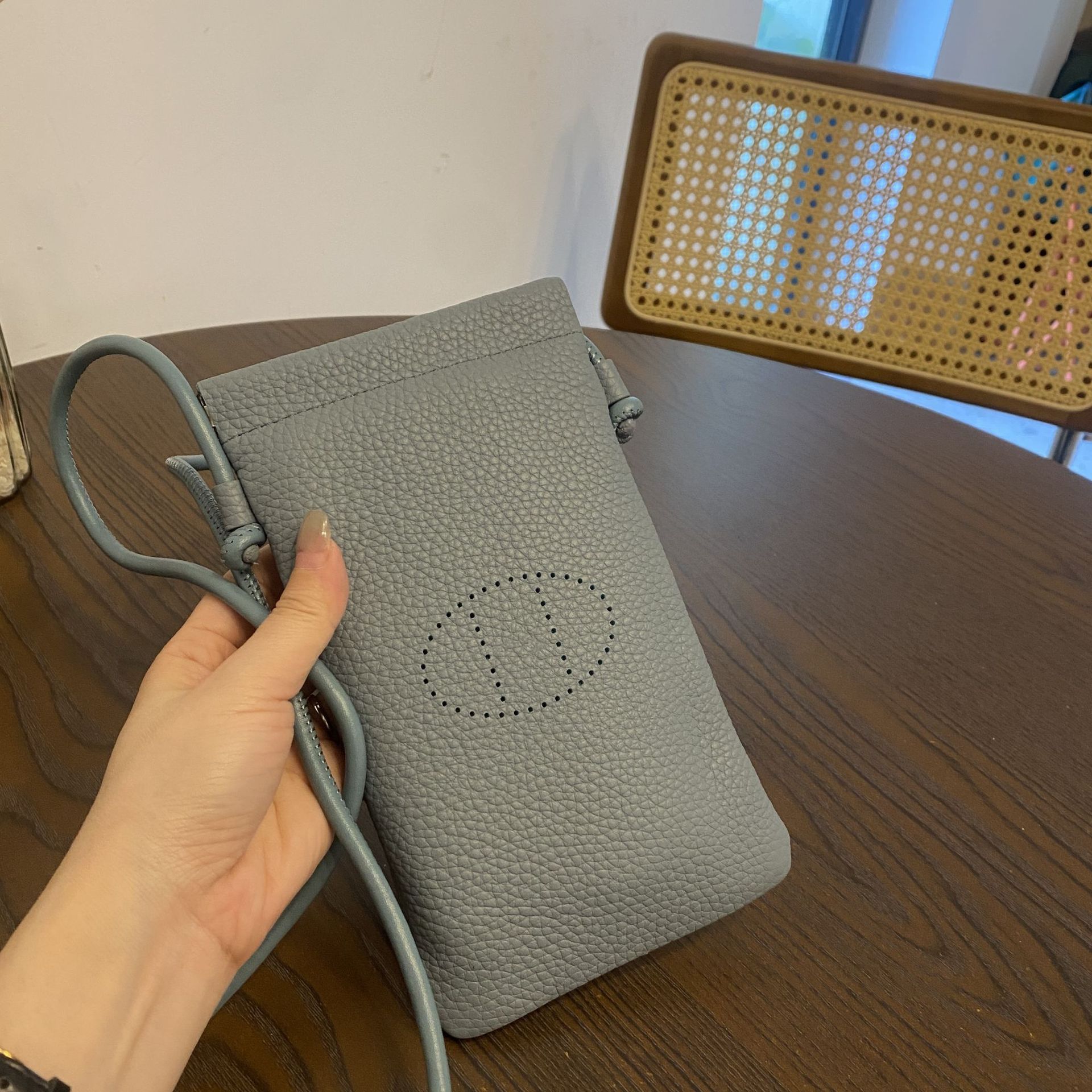 Picture of New first layer cowhide vertical mobile phone bag fashion simple shoulder messenger bag hollow soft leather drawstring small square bag