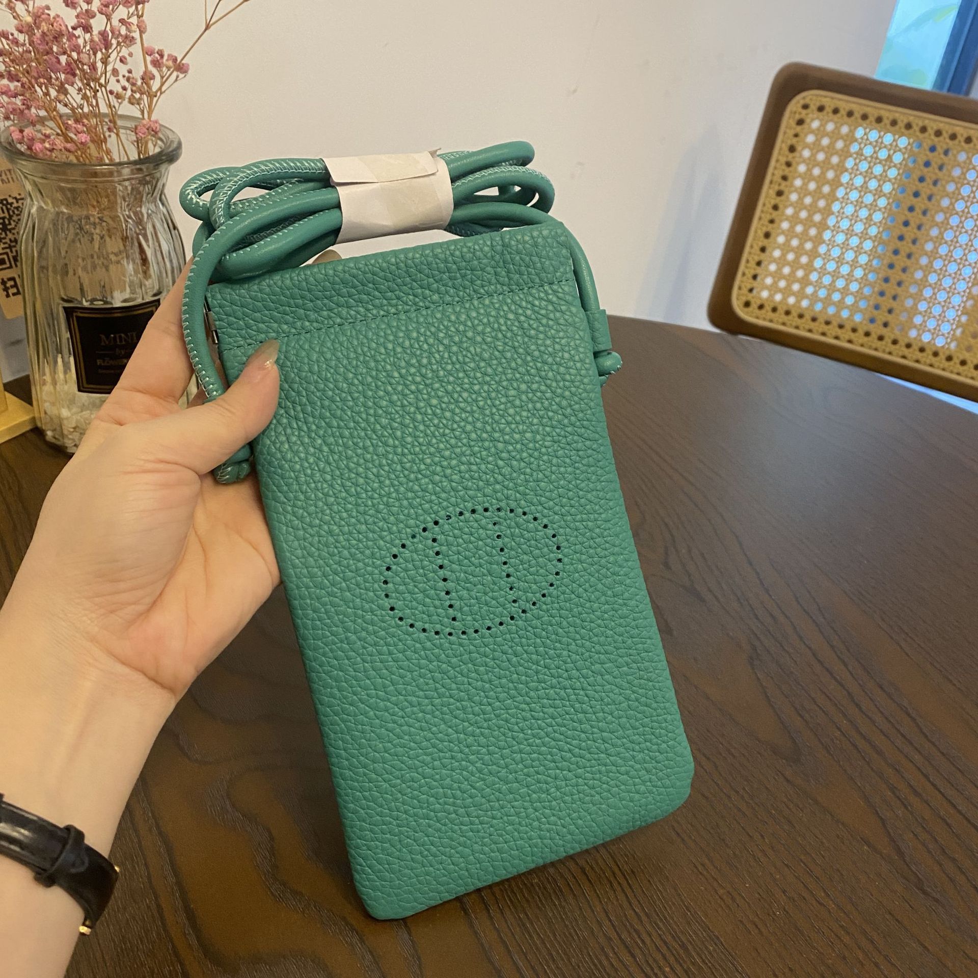 Picture of New first layer cowhide vertical mobile phone bag fashion simple shoulder messenger bag hollow soft leather drawstring small square bag